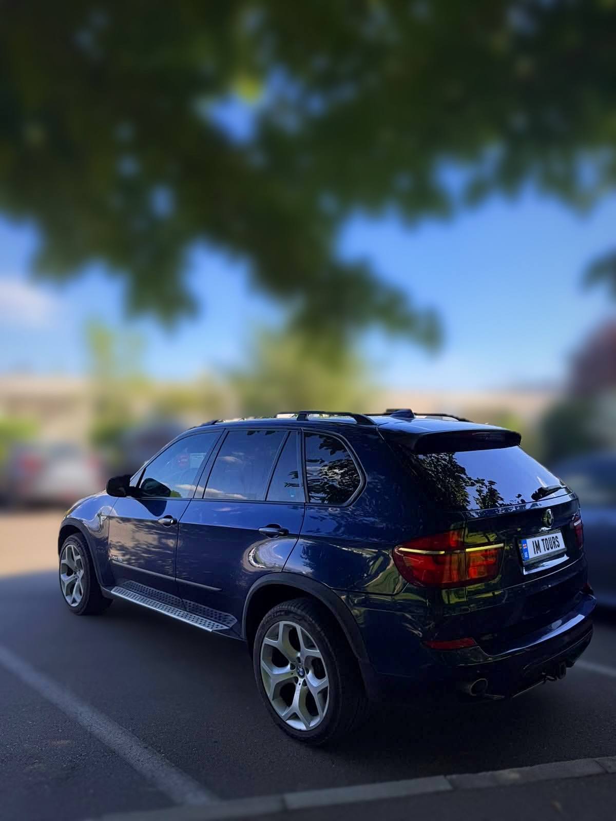 Our blue BMW X5 parked in the shade of a tree